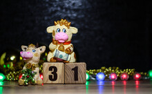 Bull And Cow Near The Wooden Cubes With The Number 31. Christmas Background With Toys.