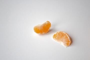 two slices of tangerine on a white background