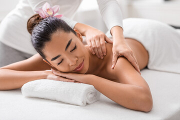 Wall Mural - Relaxed asian woman enjoying back and shouders massage in spa