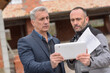 © ElitProd - Owner and contractor are reading the notes on the tablet during the construction meeting