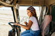 © Alvaro Sanchez/ADDICTIVE STOCK - Side view of serious female farmer operating combine harvester and collecting wheat in field in rural area