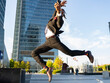 © Jose Carlos Cerdeno/ADDICTIVE STOCK - Side view of carefree black male entrepreneur in classy suit and with smartphone jumping on street in downtown