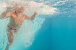 © Si And Si/ADDICTIVE STOCK - Underwater view of cropped unrecognizable kid swimming in clear water of pool and looking at camera