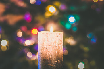 christmas festive concept with christmas tree and colorful lights and burning candle