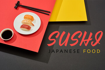 Wall Mural - fresh nigiri with salmon, shrimp and tuna near soy sauce, chopsticks and sushi japanese food lettering on red, yellow and black surface
