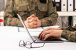© cunaplus - Military officers meet to discuss recruitment. They are using a laptop.