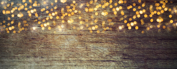 Wall Mural - Golden bokeh lights on old wooden board - rustic Christmas background - wood texture
