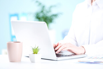 Poster - Office worker working on a laptop with cup of drink