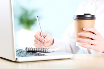Poster - Office worker working on a laptop with cup of drink