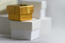 Tiny White And Gold Gift Boxes On A White Background
