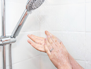 Poster - Closeup shot of female hands with foam under shower