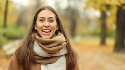 Wall Mural - smiling beautiful young woman enjoy autumn in a public park