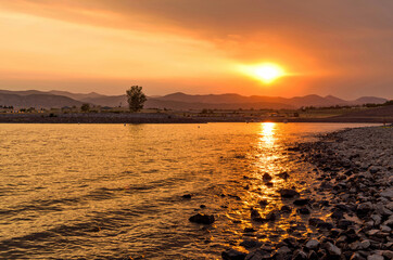 Wall Mural - Sunset Chatfield 2020 - The setting sun shines through thick haze from smoke of several wildfires in Rocky Mountains onto calm water of Chatfield Reservoir. Summer of 2020, Denver-Littleton, CO, USA.