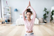 © BestForYou - Attractive young woman working out at home, doing yoga exercise.