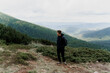 © Rabizo Anatolii - Hiking and climbing up to the top of the mountain. Men tourist is travelling and standing at the root of the mountain and watching to the peak.