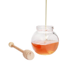 Sticker - Fresh honey pouring into a jar next to a honey spoon isolated on a white background