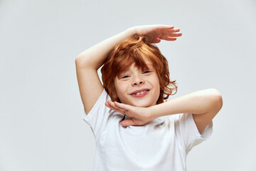 Wall Mural - Grimacing boy holding hands above head smile cropped view