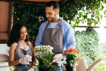 Wall Mural - Father and daughter watering potted plants at home