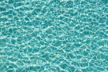 Wall Mural - Top view of beautiful swimming pool with clear water and sunlight reflection on the surface in blue and turquoise color in the morning 