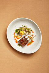 Canvas Print - Rack of lamb in white deep plate top view