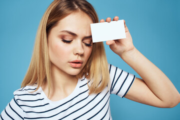 Sticker - Woman with a business card in her hands a striped T-shirt blue background Copy Space