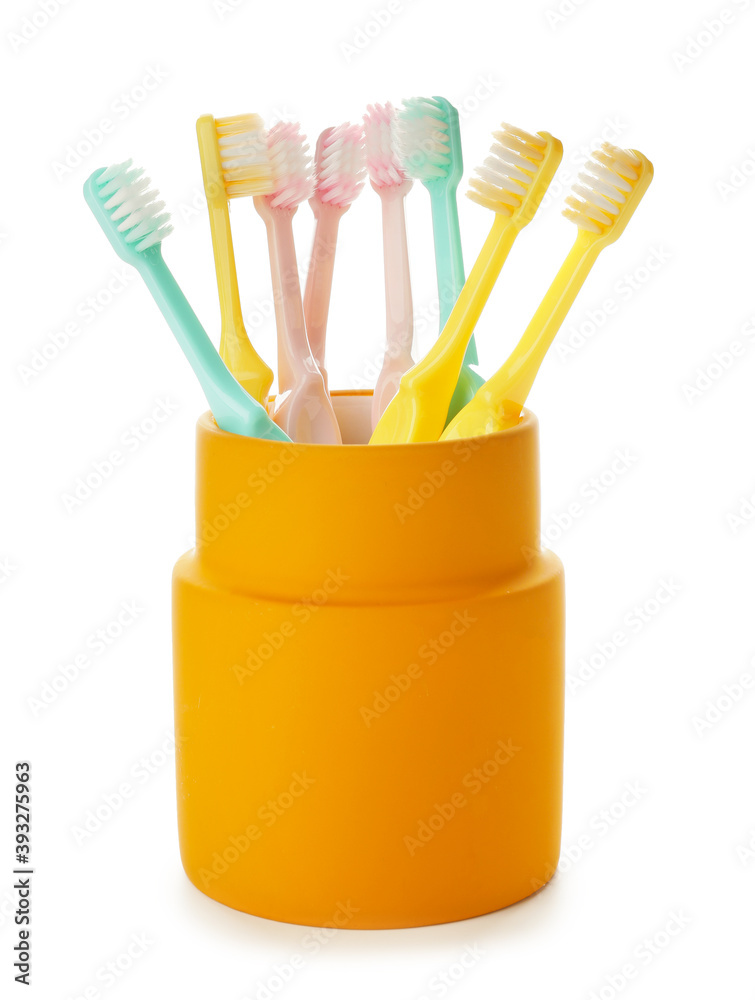 Cup with different toothbrushes on  white background