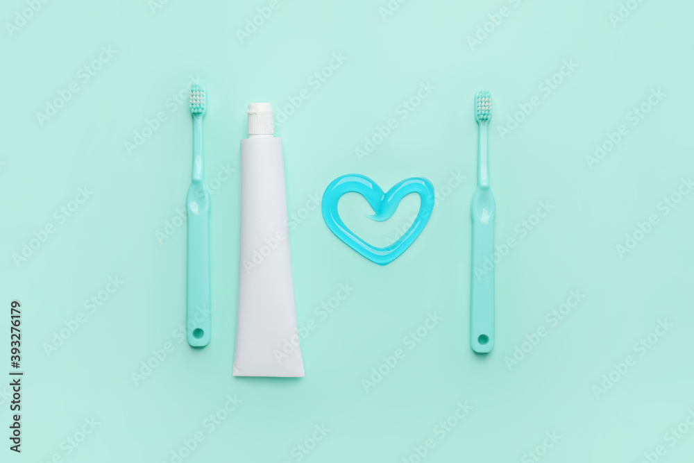 Toothbrushes and paste on color background