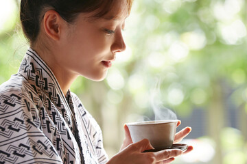 旅館の客室でリラックスをする浴衣姿の若い女性