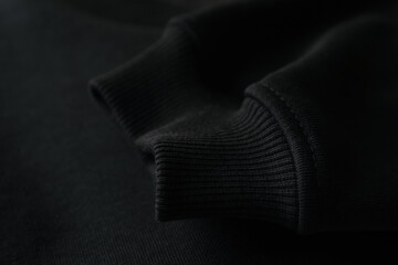 Wall Mural - Sleeve of black sweatshirt, close up and space for tet