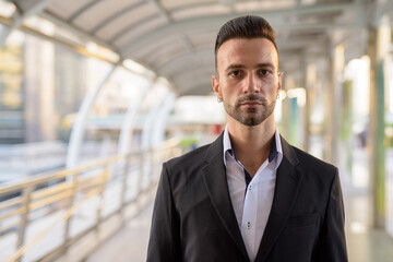 Portrait of handsome young businessman outdoors in city