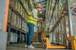 © zinkevych - Worker in a yellow vest and helmet standing near the loader