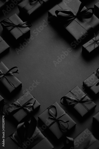 Cuadros en Lienzo Arranged Gifts boxes wrapped in black paper with black ribbon on black background