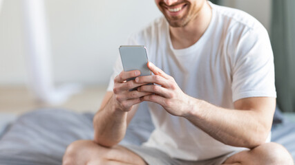 Aufkleber - Unrecognizable Guy Using Phone With Mobile Application In Bedroom, Cropped
