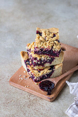 Wall Mural - Shortcrust pie bars with berries jam and crumble on wooden board, light background. Homemade bakery.