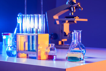 Poster - Laboratory glassware close-up. Laboratory glassware on table next to microscope. Test tubes of different shapes in laboratory. Concept - sale of test tubes for lab. Glassware for scientific research.