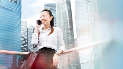 asian businesswoman talking on a phone in a city