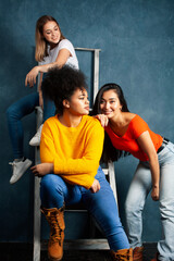 diverse nation girls group, teenage friends company cheerful having fun, happy smiling, cute posing on blue background, lifestyle people concept