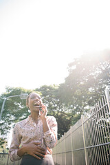 Poster - Black lady talking on a phone in the park