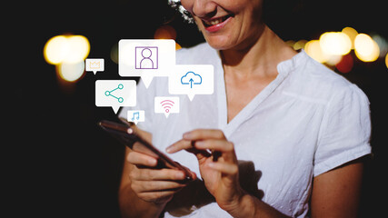 Wall Mural - Woman using her phone at night on a street