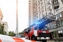 Many Fire Engine Trucks With Ladder And Safety Equipment At Accident In Highrise Tower Residential Apartment Or Office Building In City Center. Emergency Rescue At Disaster
