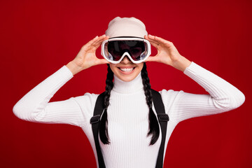 Photo of young happy positive smiling girl wear goggles celebrate new year in resort isolated on red color background