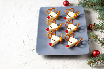 Wall Mural - Funny christmas snack in a shapes of deer for kids party. Concept New year food from cheese and pretzels