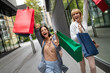 © NDABCREATIVITY - Beautiful happy women with shopping bags walking at the mall