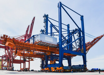 Wall Mural - Transporting huge quay crane using self-propelled modular transporter. Moving huge quay crane from ship to harbor. 