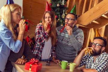 Canvas Print - People blowing party whistles while celebrating friend's birthday