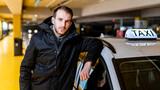 Fototapeta  - Taxi driver posing with his car at the underground parking