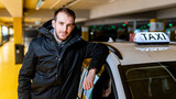 Fototapeta  - Taxi driver posing with his car at the underground parking
