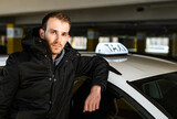 Fototapeta  - Young taxi driver posing with his car