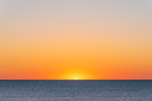 Orange Sunrise Over The Ocean And Sandy Beach