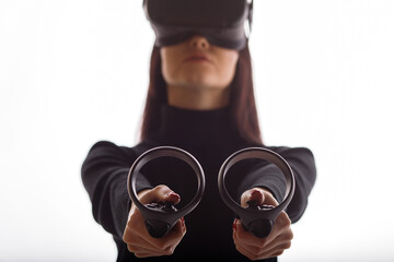 Wall Mural - girl in glasses of virtual reality with controllers in hands. augmented reality concept. free space 